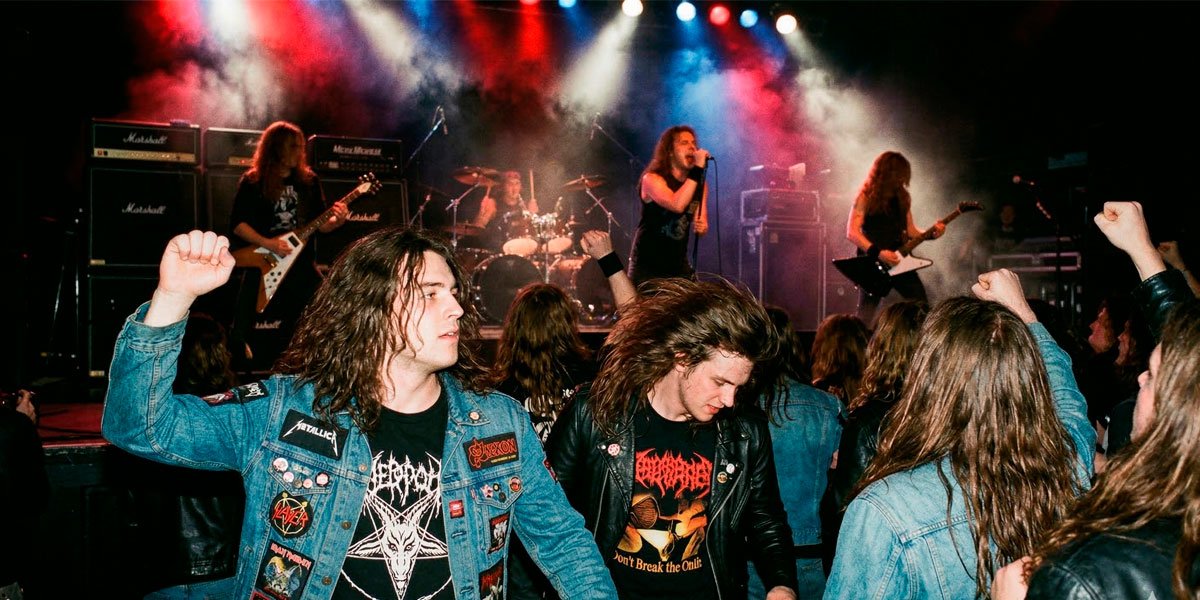 Fans usando playeras de heavy metal en concierto de rock